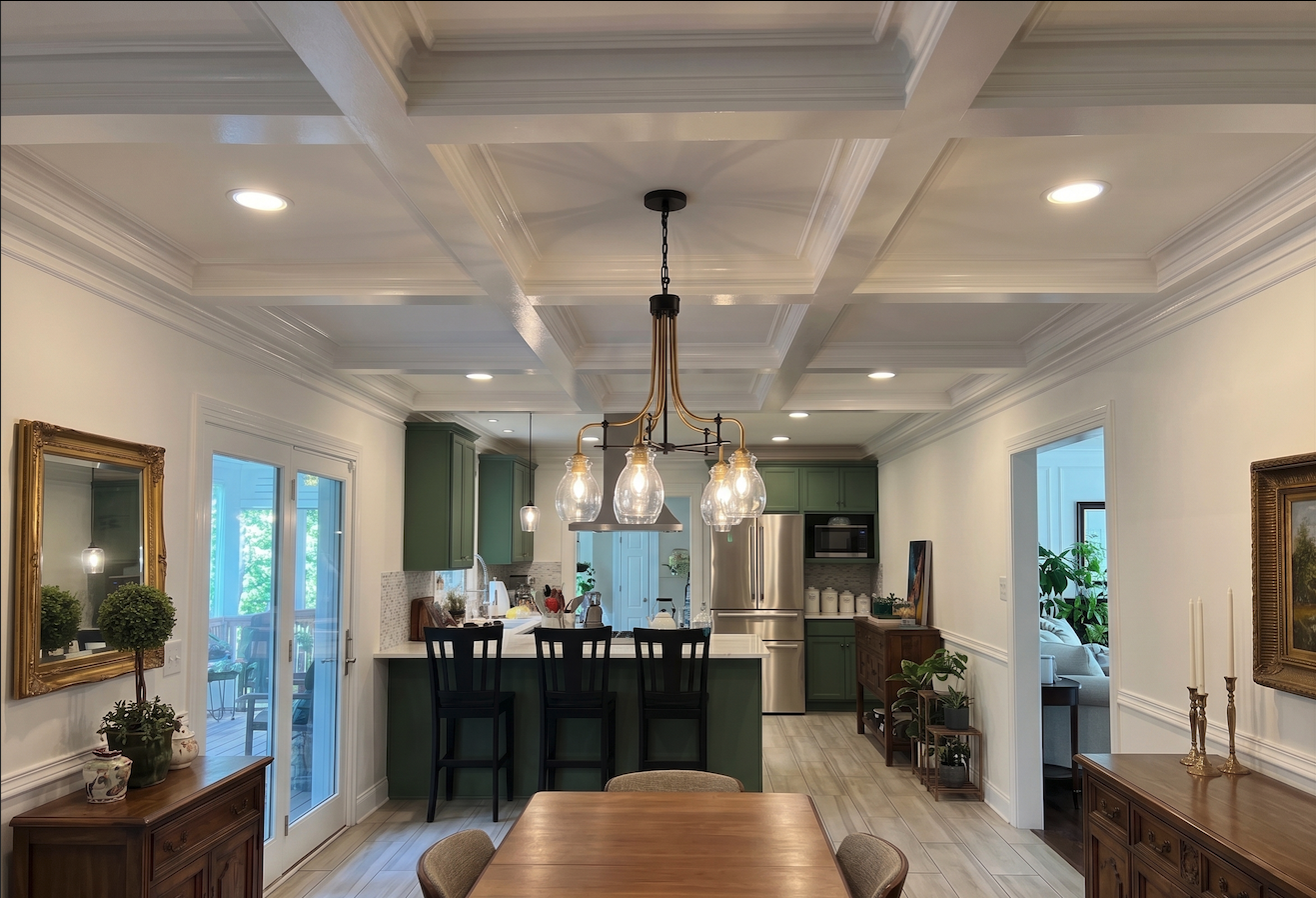 Remodeled open-concept kitchen and dining room with a coffered ceiling and green cabinetry by Warner's Remodeling